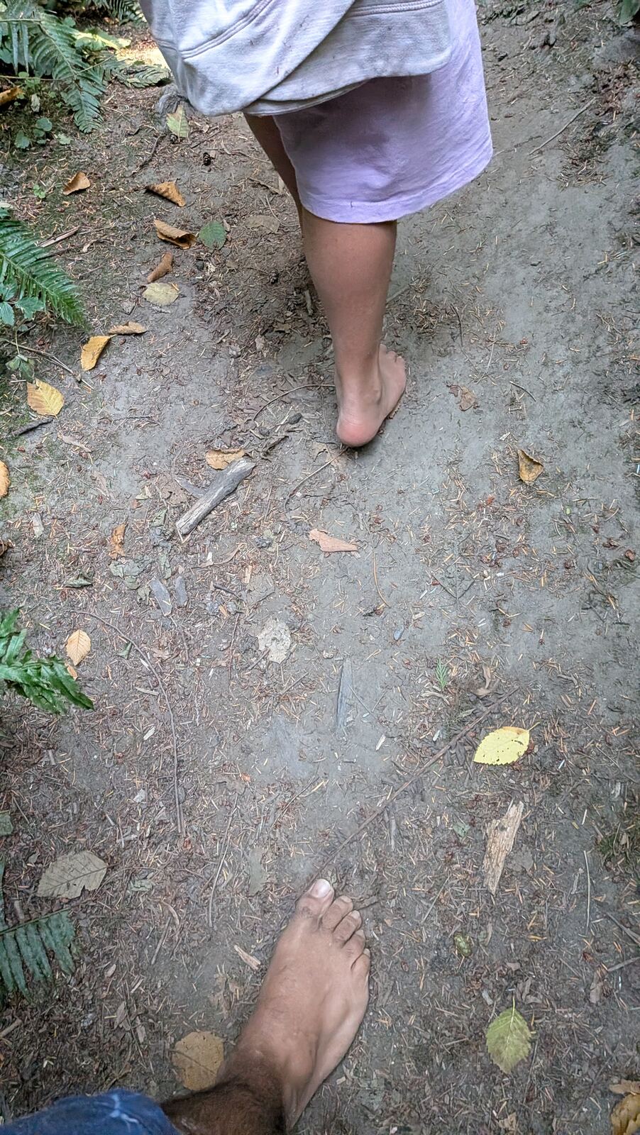 Bare feet walking along a forest dirt trail